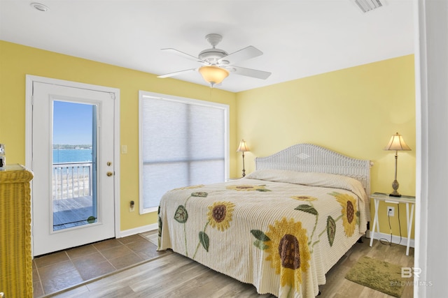 bedroom with visible vents, baseboards, ceiling fan, wood finished floors, and access to outside