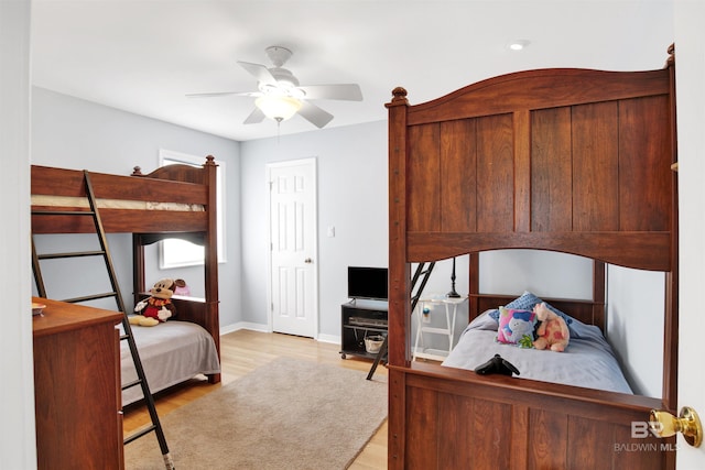 bedroom featuring light wood finished floors, ceiling fan, and baseboards