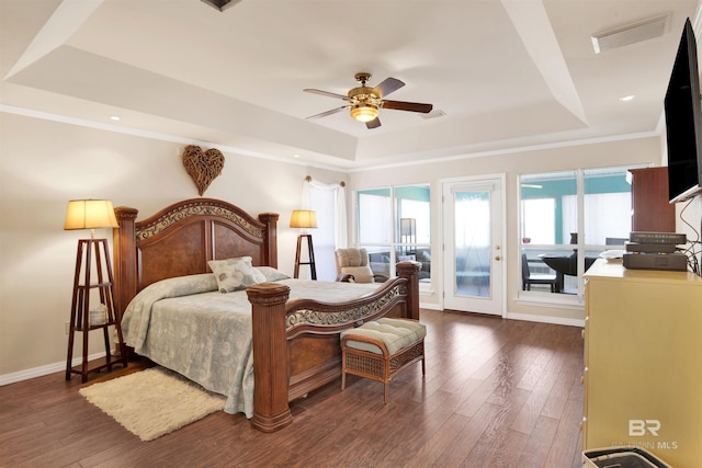 bedroom featuring visible vents, a raised ceiling, dark wood-type flooring, baseboards, and access to exterior