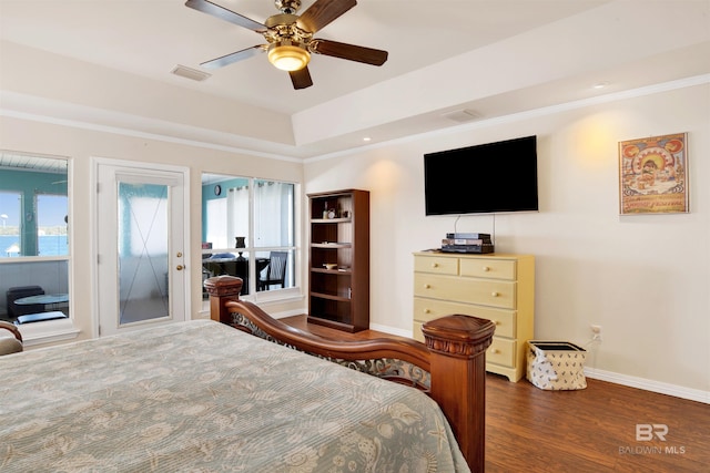 bedroom featuring visible vents, crown molding, baseboards, and wood finished floors