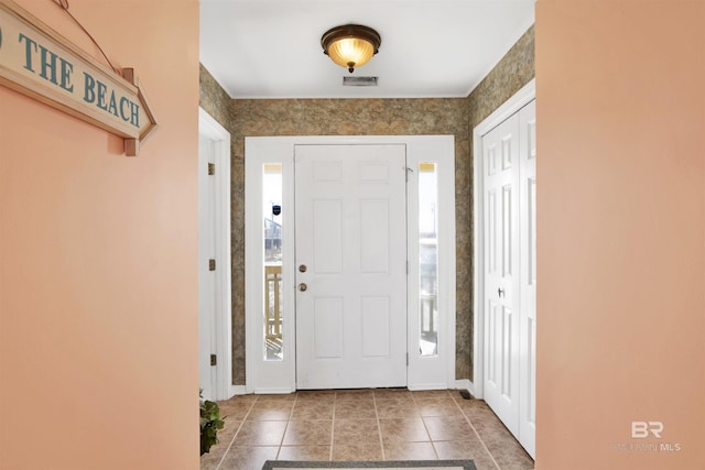 entryway featuring tile patterned flooring, baseboards, and visible vents