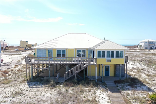 rear view of house featuring a deck, stairway, and metal roof