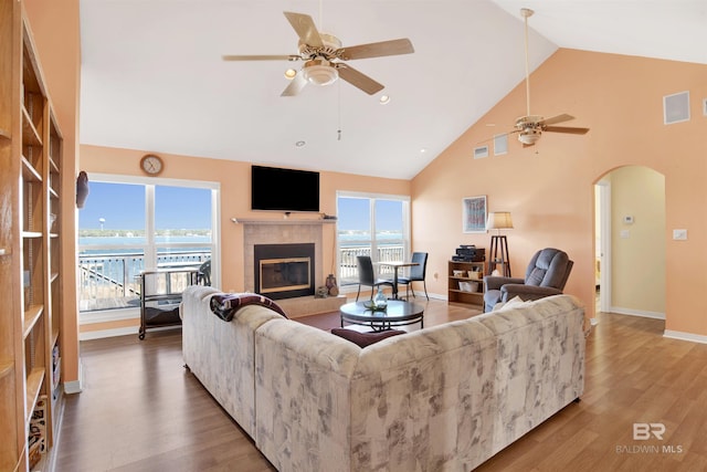 living area with a fireplace, plenty of natural light, wood finished floors, and visible vents