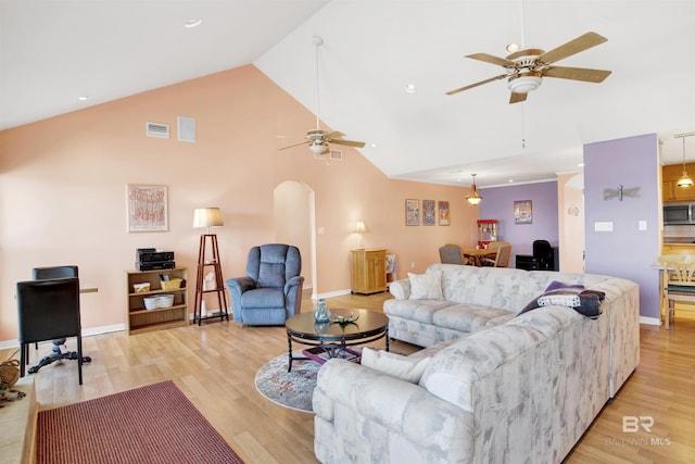 living room featuring visible vents, high vaulted ceiling, light wood-style flooring, arched walkways, and ceiling fan