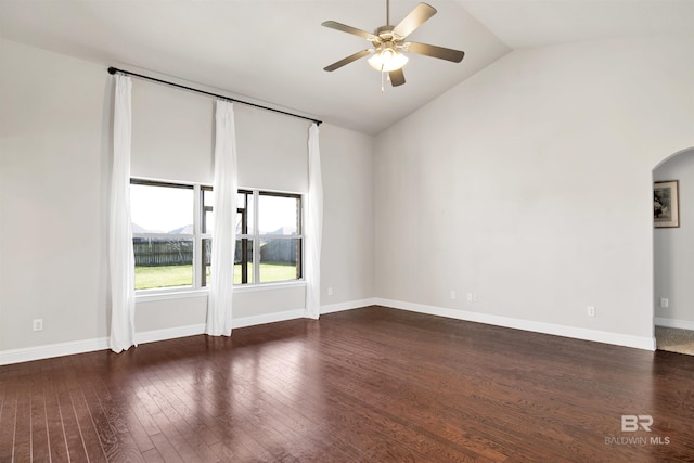 unfurnished room with a ceiling fan, wood finished floors, baseboards, lofted ceiling, and arched walkways