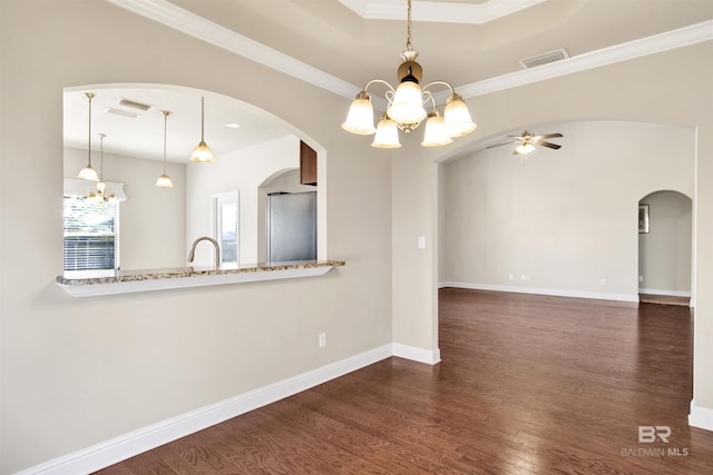 interior space featuring baseboards, arched walkways, dark wood-style floors, and ceiling fan with notable chandelier