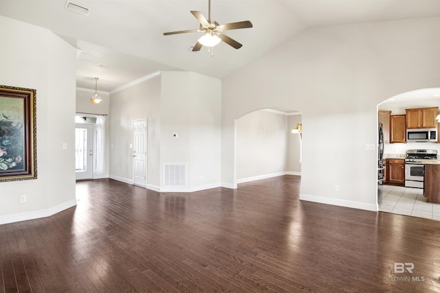 unfurnished living room featuring visible vents, arched walkways, and ceiling fan