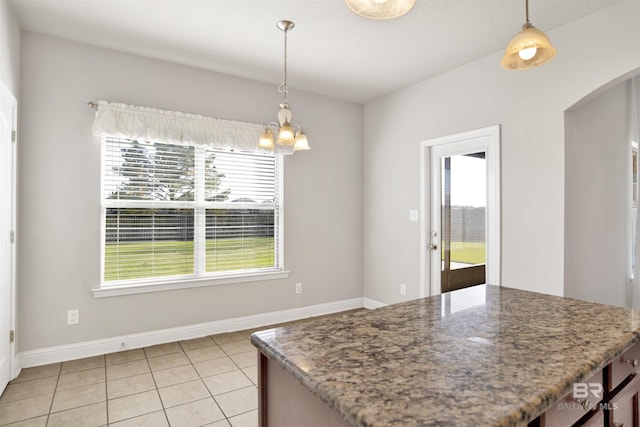 kitchen featuring light tile patterned floors, arched walkways, a chandelier, and pendant lighting