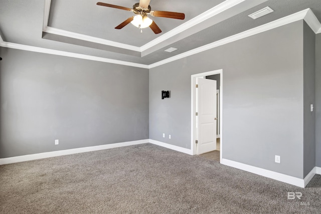 spare room featuring visible vents, a raised ceiling, carpet floors, and ceiling fan