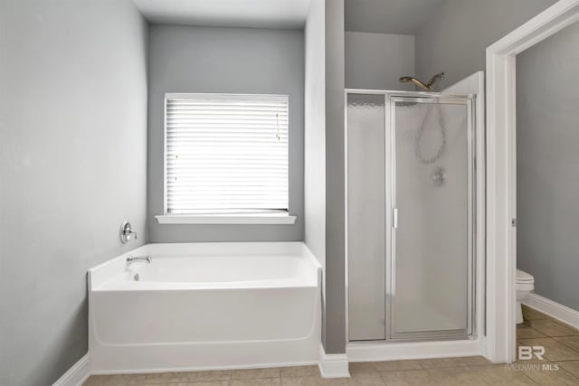 bathroom with a bath, baseboards, a shower stall, tile patterned floors, and toilet