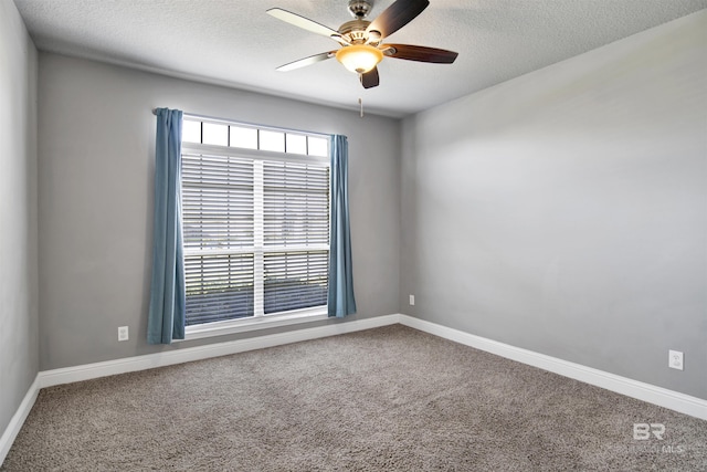 carpeted spare room featuring a healthy amount of sunlight, a textured ceiling, and a ceiling fan