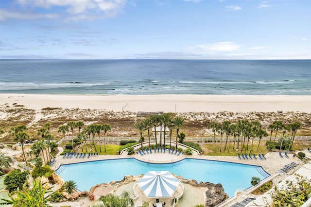 view of swimming pool with a water view and a view of the beach