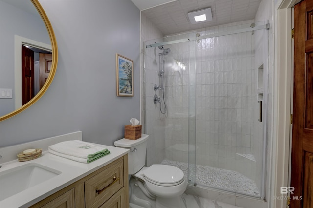 bathroom featuring vanity, toilet, and a shower with shower door