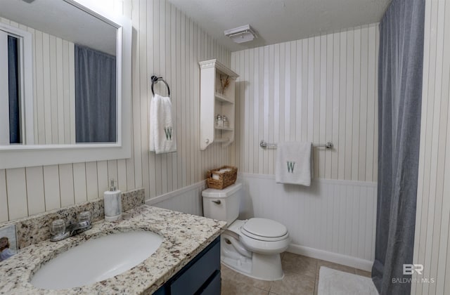 bathroom with tile patterned flooring, vanity, and toilet