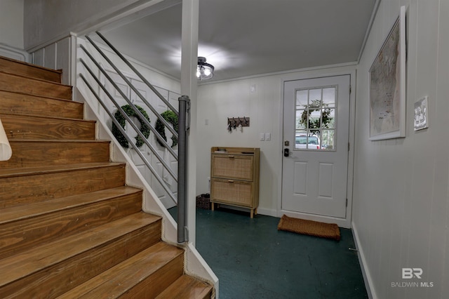 foyer with concrete flooring and crown molding