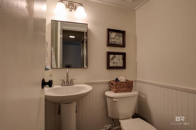 bathroom with toilet and crown molding