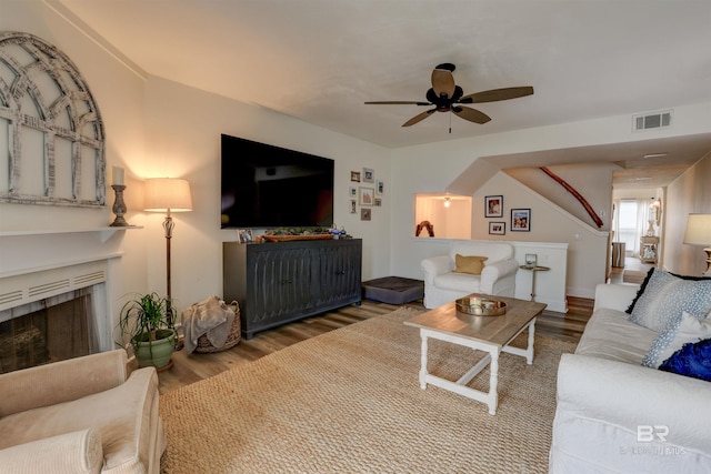 living room featuring wood-type flooring and ceiling fan