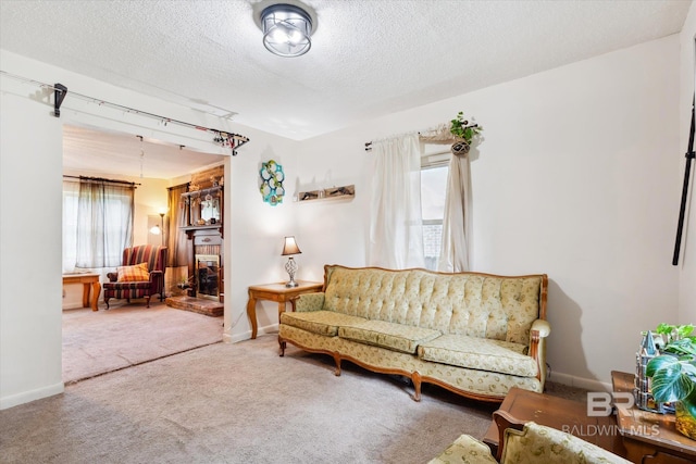 living room featuring carpet floors, a brick fireplace, and a textured ceiling