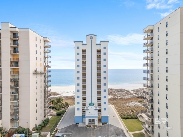 view of property with a water view and a beach view