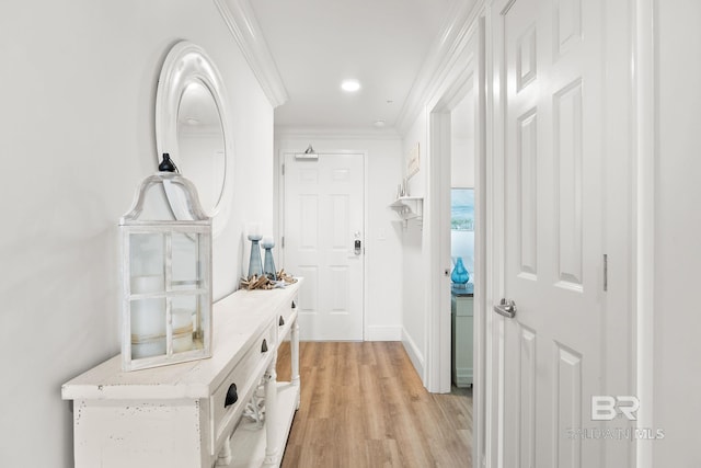 corridor with baseboards, light wood-style flooring, and crown molding