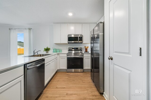 16770 Prado Loop, Loxley, AL 36551 - kitchen with appliances with stainless steel finishes, light wood-style flooring, white cabinetry, light countertops, and recessed lighting