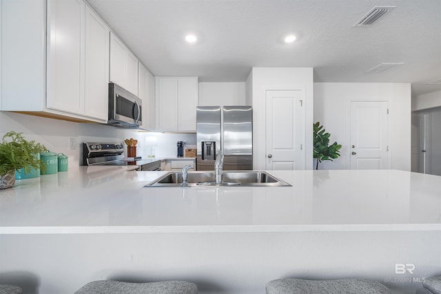 16770 Prado Loop, Loxley, AL 36551 - kitchen featuring appliances with stainless steel finishes, light countertops, recessed lighting, white cabinets, and a peninsula