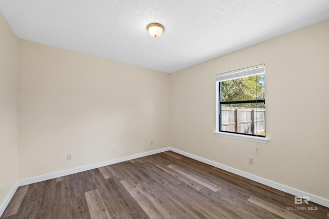 unfurnished room with hardwood / wood-style floors and a textured ceiling