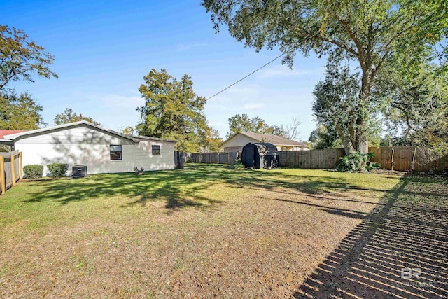 view of yard featuring central AC unit and a storage unit