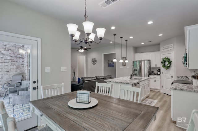 dining area featuring recessed lighting, visible vents, light wood-style flooring, and ceiling fan with notable chandelier