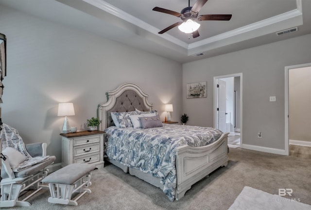 bedroom with carpet flooring, crown molding, visible vents, and a raised ceiling