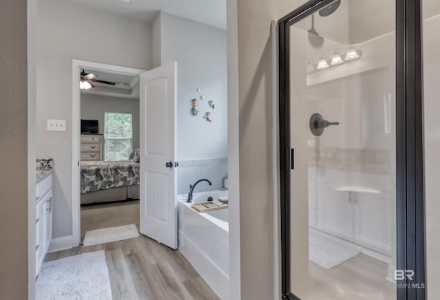 bathroom featuring a bath, ensuite bath, wood finished floors, and a shower stall