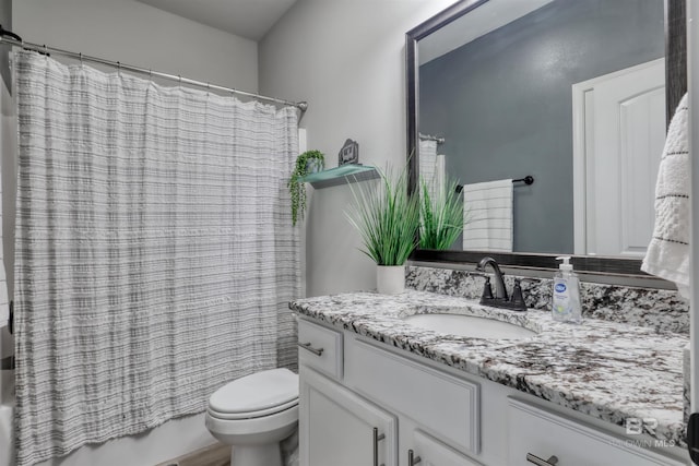 bathroom featuring toilet, shower / tub combo with curtain, and vanity