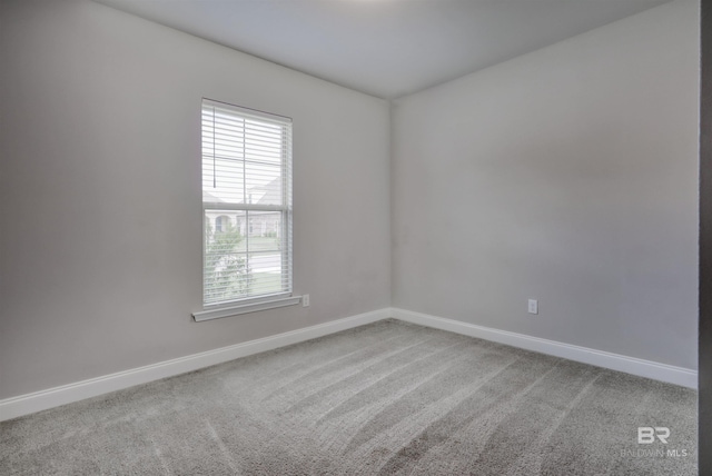 carpeted spare room with baseboards