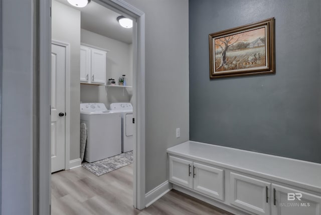 mudroom featuring separate washer and dryer, baseboards, and light wood-style flooring