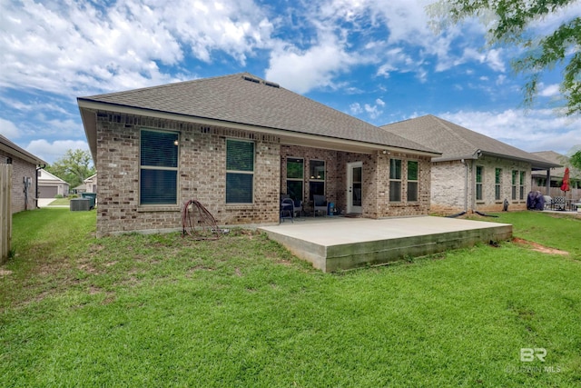 rear view of house featuring a lawn, brick siding, a patio, and roof with shingles