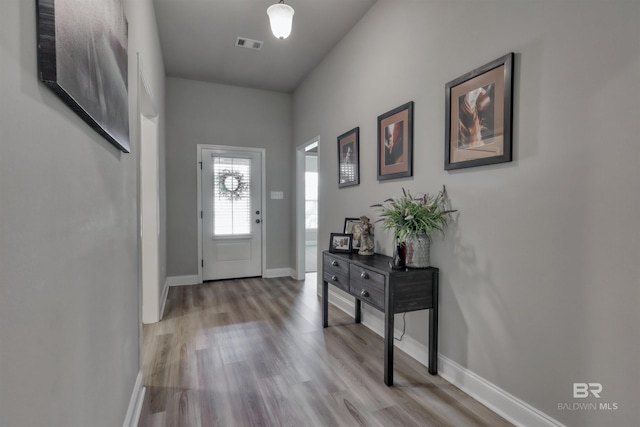 entryway featuring baseboards, light wood-type flooring, and visible vents
