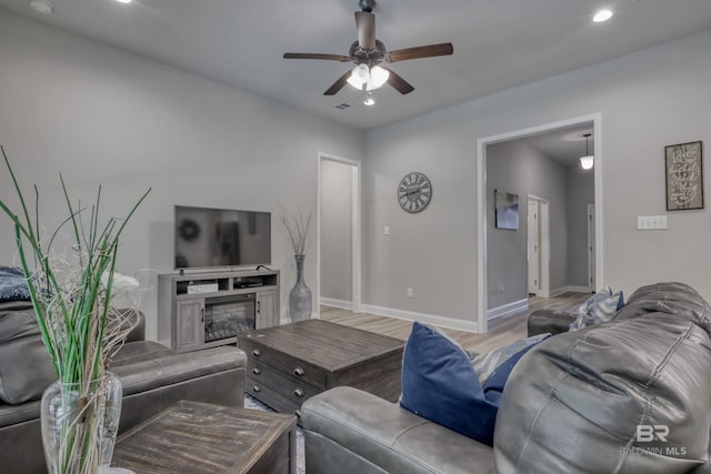 living area with baseboards, ceiling fan, recessed lighting, and wood finished floors