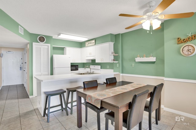 dining room featuring baseboards, visible vents, a textured ceiling, and light tile patterned flooring