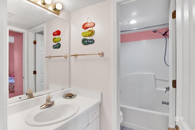 full bathroom with shower / tub combination, a textured ceiling, toilet, and vanity