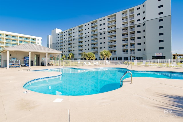 pool with a patio area and fence