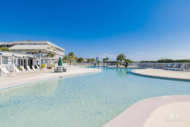 pool with a patio area and fence