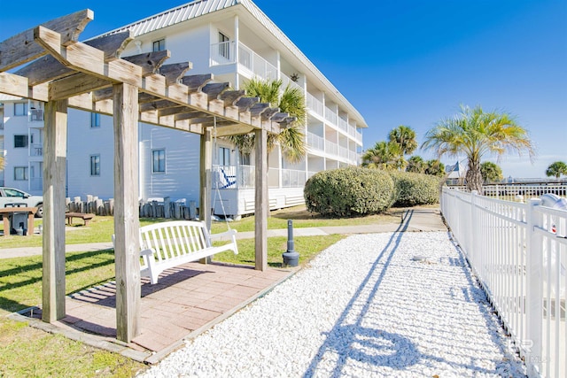 view of property's community featuring fence, a pergola, and a yard