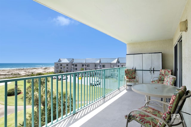 balcony featuring a water view and a view of the beach