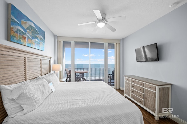 bedroom with baseboards, a ceiling fan, dark wood-style floors, access to outside, and a textured ceiling