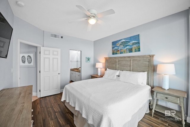 bedroom featuring dark wood-style flooring, visible vents, ensuite bathroom, ceiling fan, and baseboards