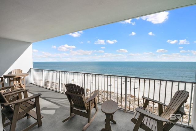 balcony with a water view and a view of the beach