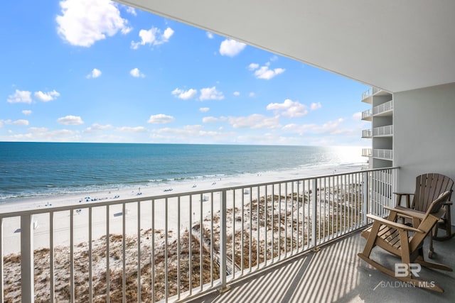 balcony with a water view and a view of the beach