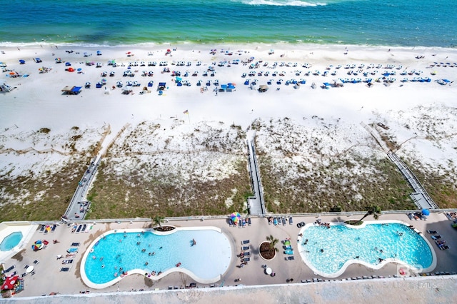 drone / aerial view featuring a beach view and a water view