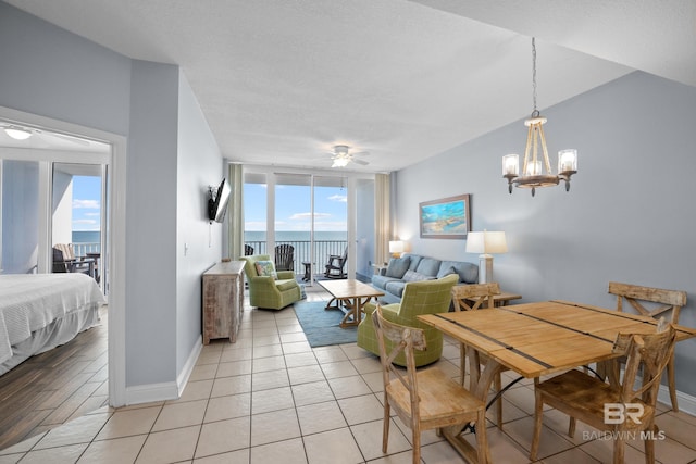 dining space featuring light tile patterned flooring, floor to ceiling windows, baseboards, and ceiling fan with notable chandelier