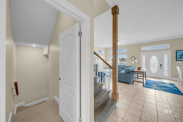 stairway with tile patterned floors, baseboards, ornamental molding, and ornate columns